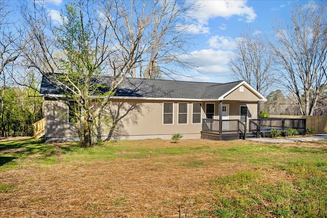 view of front of home with a porch, a front yard, and a shingled roof