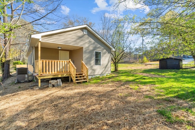 exterior space featuring a shed, cooling unit, an outdoor structure, and a yard