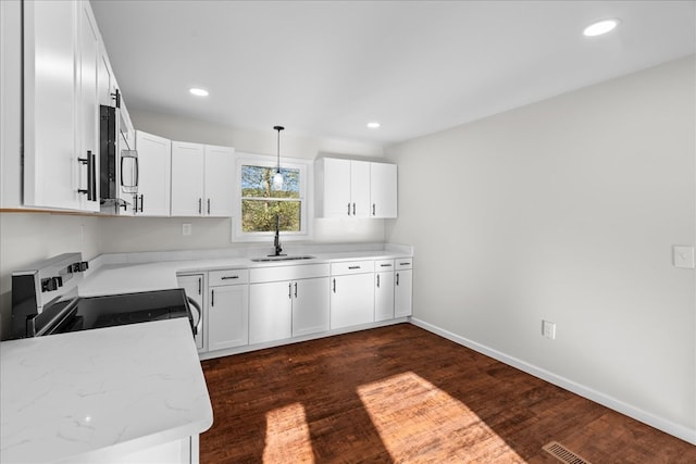 kitchen featuring baseboards, stainless steel appliances, recessed lighting, dark wood-type flooring, and a sink
