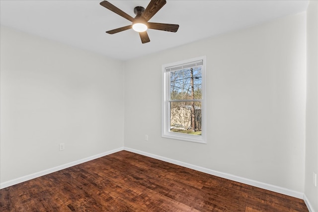 spare room featuring a ceiling fan, dark wood-type flooring, and baseboards