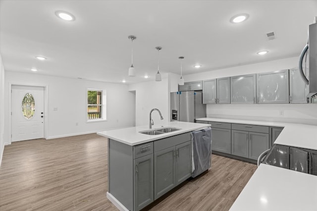 54 Austin Dr, Rossville, GA 30741 - kitchen featuring appliances with stainless steel finishes, gray cabinetry, an island with sink, light wood-type flooring, and light countertops