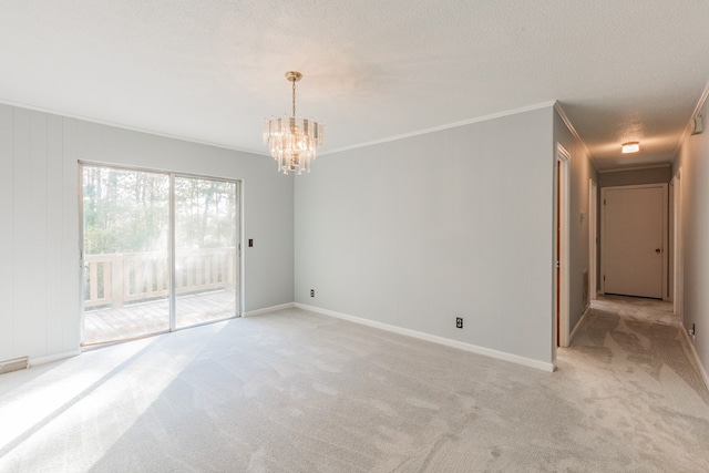 spare room featuring ornamental molding, light colored carpet, a notable chandelier, and a textured ceiling