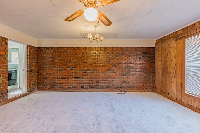 carpeted empty room with brick wall, ceiling fan, and wood walls