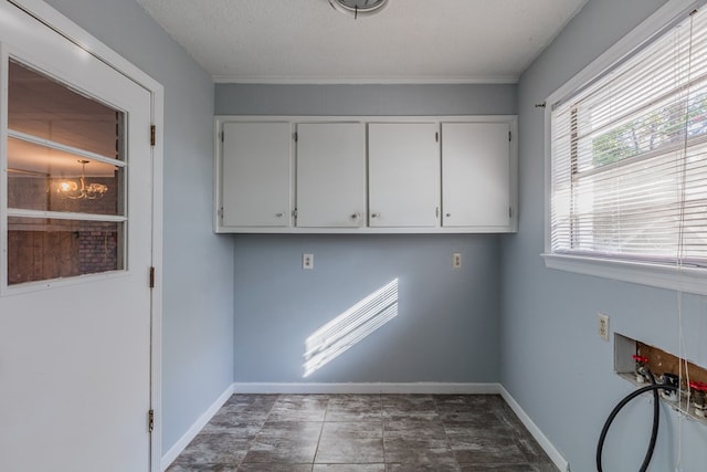 washroom with hookup for a washing machine, cabinets, and a textured ceiling