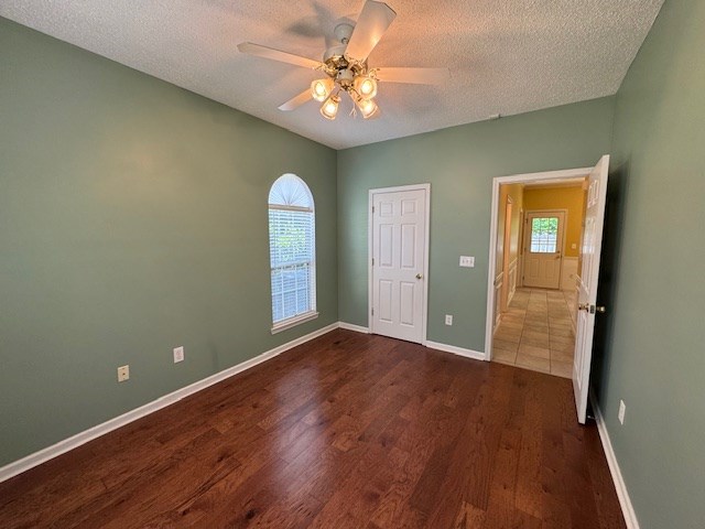 1694 Red Oak Dr Unit 185, Dalton, GA 30721 - empty room with dark wood-style flooring, a textured ceiling, ceiling fan, and baseboards