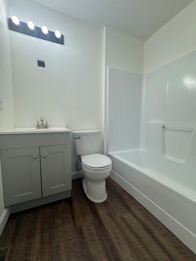 408 Ridgecrest Dr, Lafayette, GA 30728 - bathroom with wood finished floors, toilet, vanity, a textured ceiling, and washtub / shower combination