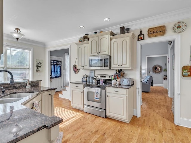 1000 Robin Way, Rocky Face, GA 30740 - kitchen featuring appliances with stainless steel finishes, a sink, ornamental molding, light wood-style flooring, and dark stone counters
