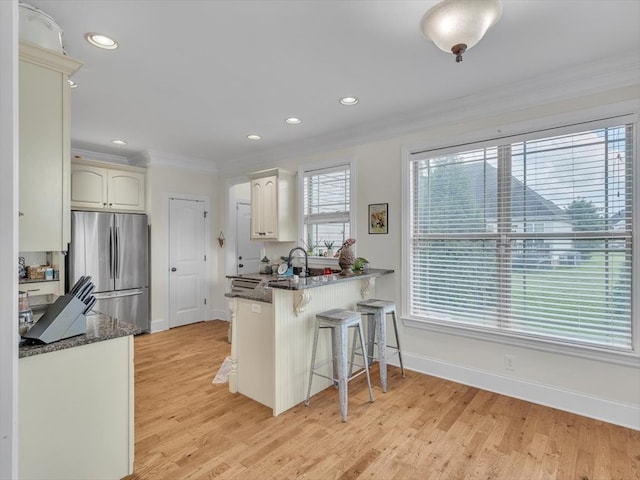 1000 Robin Way, Rocky Face, GA 30740 - kitchen featuring freestanding refrigerator, crown molding, a kitchen breakfast bar, a peninsula, and light wood finished floors