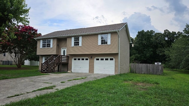 split foyer home featuring a garage and a front yard