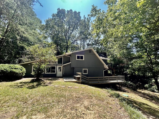 rear view of property featuring a yard and a deck