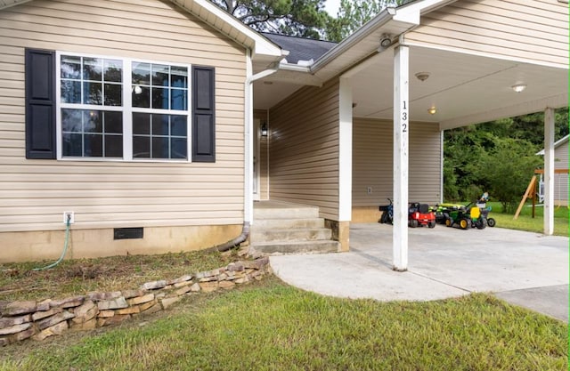 entrance to property featuring a patio area and a lawn