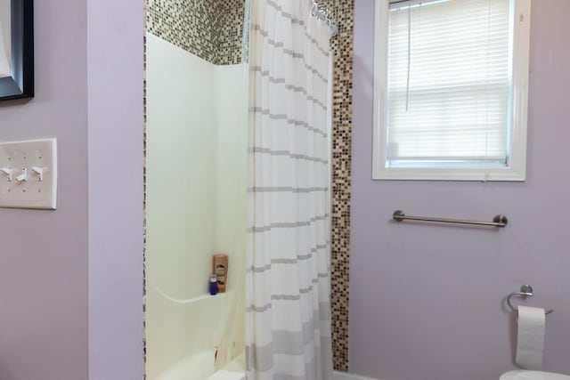 bathroom featuring toilet and shower / bath combo