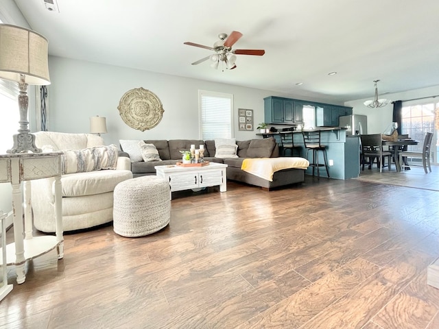 living room featuring hardwood / wood-style flooring and ceiling fan with notable chandelier