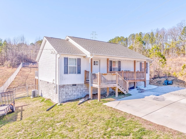 view of front of house with central AC unit, covered porch, and a front yard