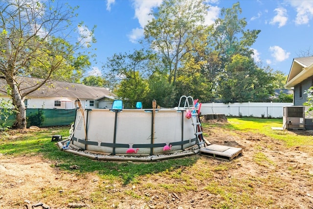 view of yard featuring a fenced in pool and central AC unit