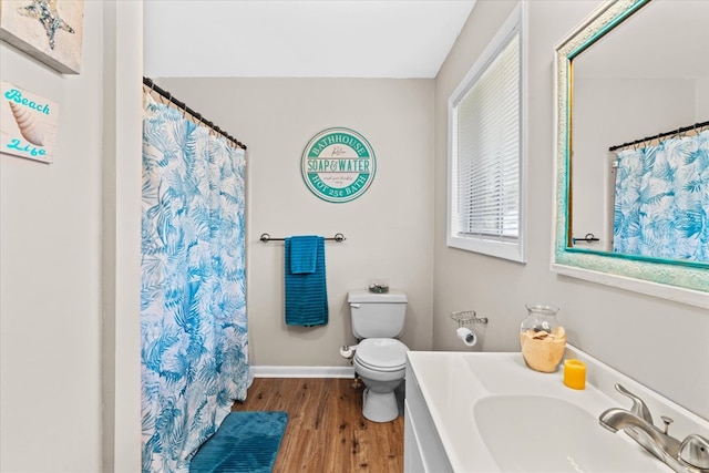 bathroom featuring vanity, wood-type flooring, toilet, and walk in shower