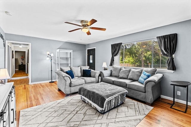 living room with light hardwood / wood-style flooring and ceiling fan