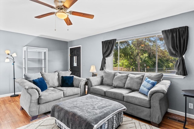 living room featuring hardwood / wood-style floors and ceiling fan