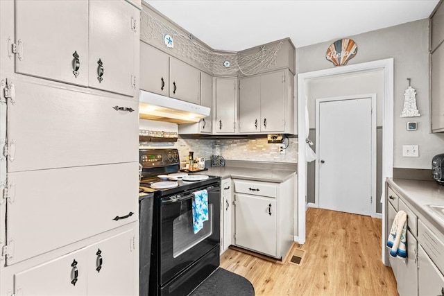 kitchen featuring tasteful backsplash, light wood-type flooring, and electric range