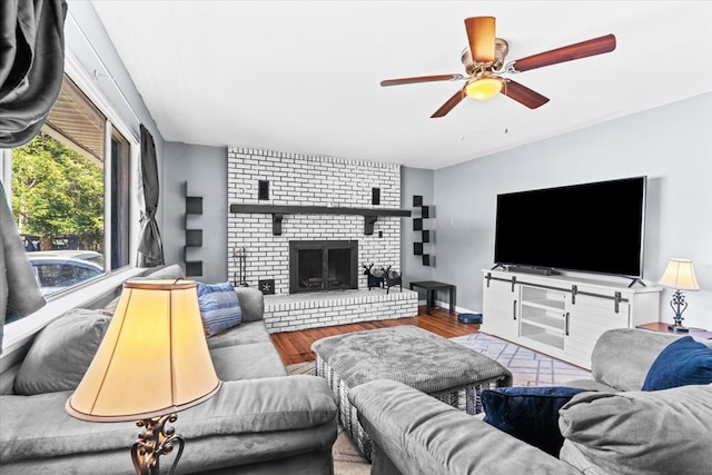 living room with ceiling fan, a fireplace, and light hardwood / wood-style floors