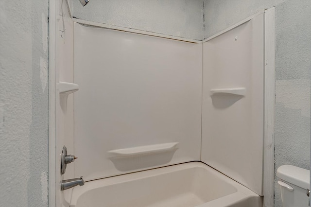 bathroom featuring shower / bathtub combination and toilet