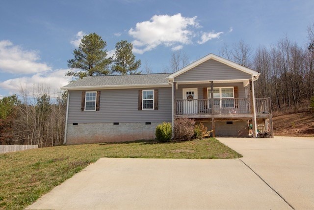 ranch-style house with a front yard, covered porch, driveway, and crawl space