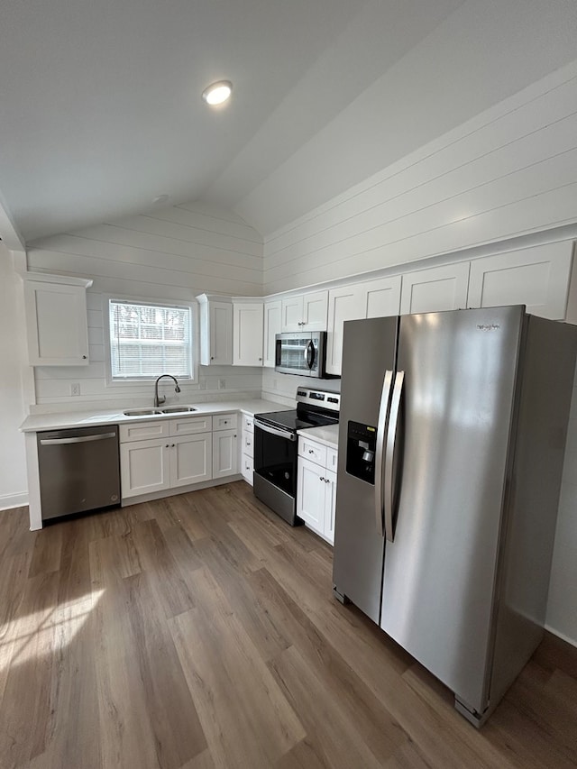 301 Shady Dr, Dalton, GA 30721 - kitchen with appliances with stainless steel finishes, lofted ceiling, wood finished floors, white cabinetry, and light countertops