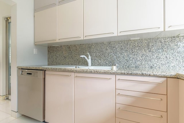 kitchen featuring white cabinetry, sink, decorative backsplash, stainless steel dishwasher, and light stone countertops