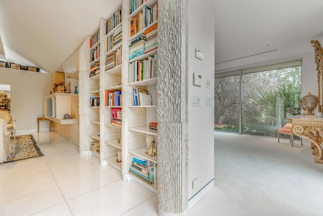 hall featuring vaulted ceiling and light tile patterned floors