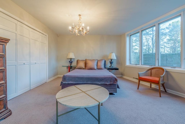 carpeted bedroom with an inviting chandelier and a closet