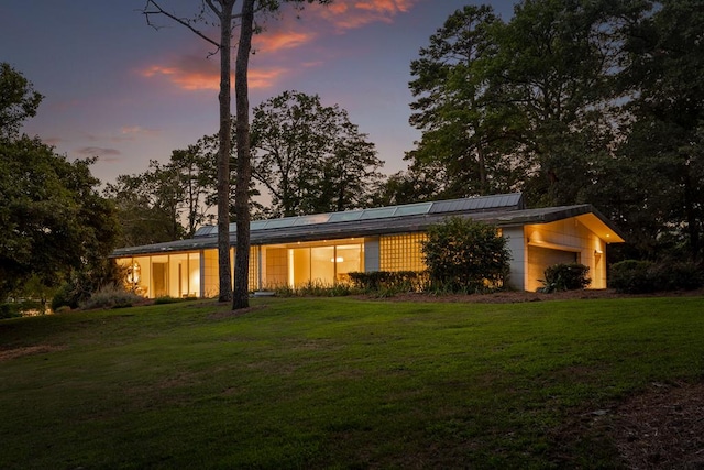 view of front of home with a garage and a lawn