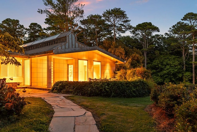 outdoor structure at dusk with a yard