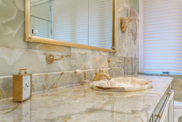 bathroom featuring vanity, backsplash, and toilet