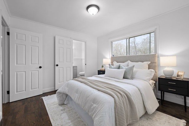 bedroom featuring dark wood-style flooring, connected bathroom, baseboards, and crown molding
