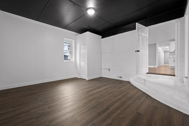 spare room featuring wood finished floors and baseboards