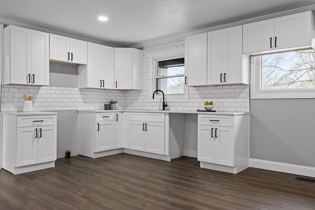 kitchen featuring white cabinetry, dark wood-style flooring, decorative backsplash, light countertops, and recessed lighting
