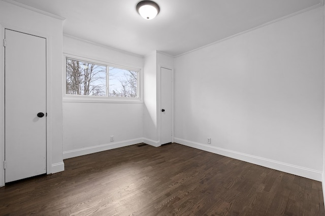 unfurnished bedroom featuring dark wood-style floors, baseboards, and crown molding