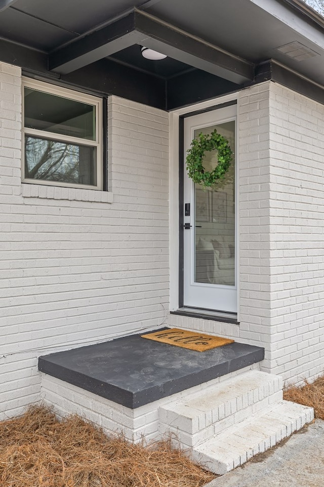 property entrance featuring brick siding