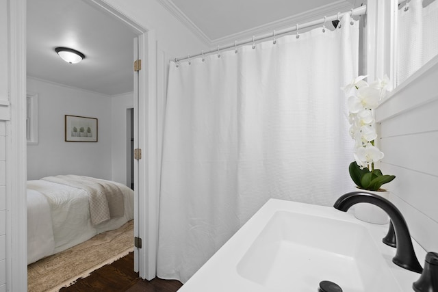 bathroom with ornamental molding, a sink, wood finished floors, and a shower with curtain