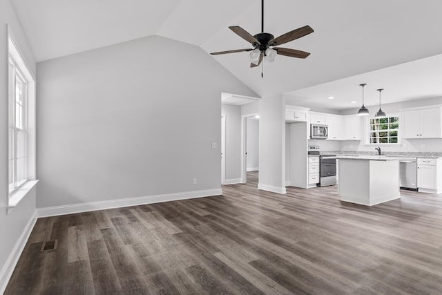 unfurnished living room with vaulted ceiling, sink, ceiling fan, and dark hardwood / wood-style flooring