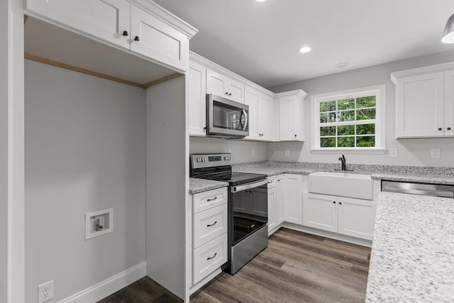 kitchen with stainless steel appliances, white cabinetry, light stone countertops, and dark hardwood / wood-style floors