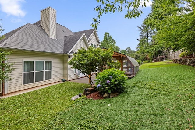 604 Lenna Ln, Dalton, GA 30720 - view of home's exterior featuring a lawn, a patio, a shingled roof, and a chimney