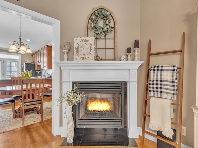 1501 Augusta Dr Unit 1, Dalton, GA 30721 - detailed view of wood finished floors, a fireplace with flush hearth, freestanding refrigerator, a chandelier, and recessed lighting