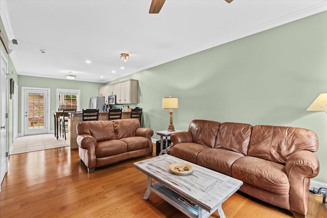 living room with crown molding and light hardwood / wood-style floors