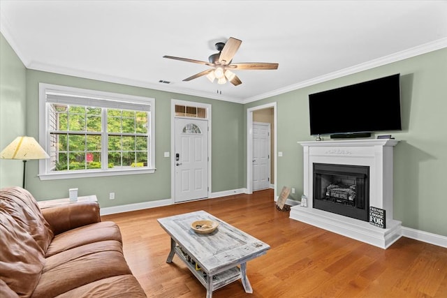 living room featuring crown molding, light hardwood / wood-style floors, and ceiling fan