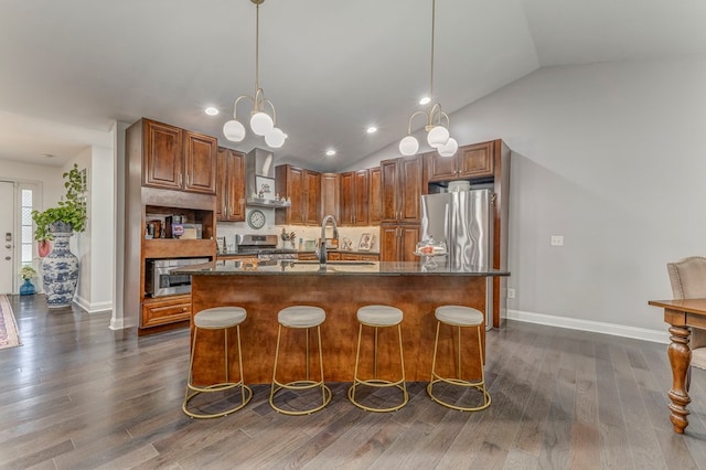 1505 Anthony Ave, Dalton, GA 30720 - kitchen with appliances with stainless steel finishes, wall chimney exhaust hood, an island with sink, vaulted ceiling, and dark wood-type flooring