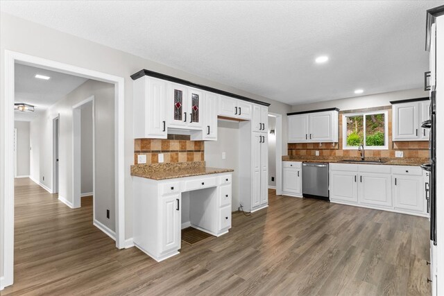 2219 Rocky Face Cir, Dalton, GA 30740 - kitchen with stainless steel dishwasher, wood finished floors, backsplash, dark stone countertops, and white cabinetry