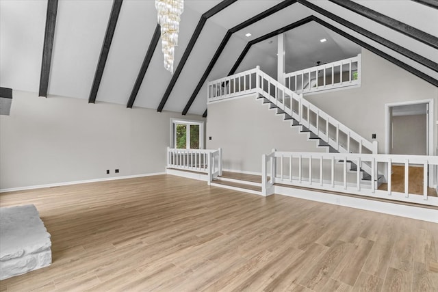 2219 Rocky Face Cir, Dalton, GA 30740 - unfurnished living room with high vaulted ceiling, a chandelier, beamed ceiling, stairs, and wood finished floors