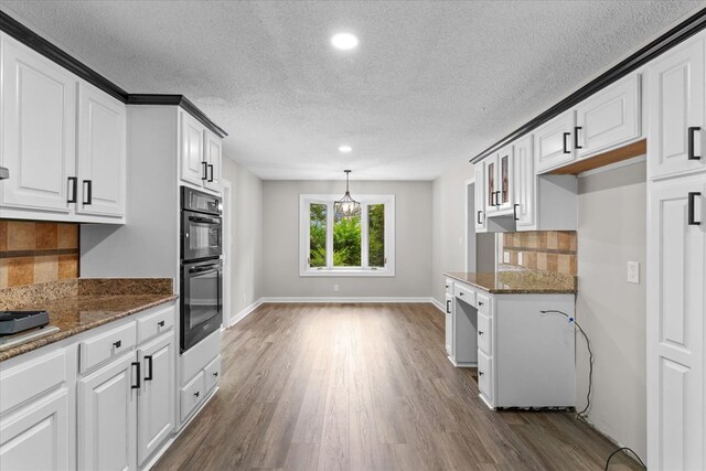 2219 Rocky Face Cir, Dalton, GA 30740 - kitchen featuring dark wood-style flooring, recessed lighting, white cabinets, tasteful backsplash, and dark stone counters