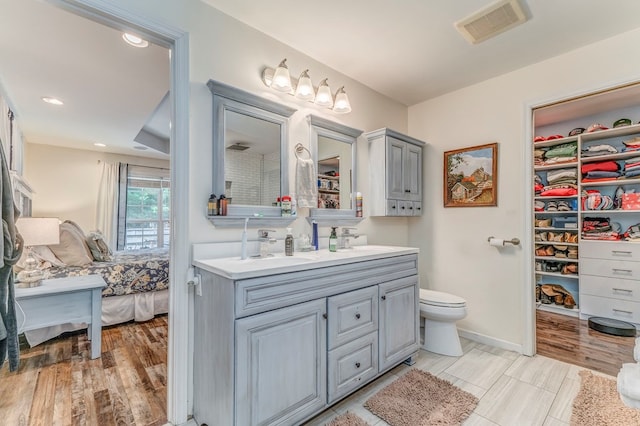 201 Tibbs Rd, Dalton, GA 30720 - ensuite bathroom featuring double vanity, wood finished floors, recessed lighting, and toilet